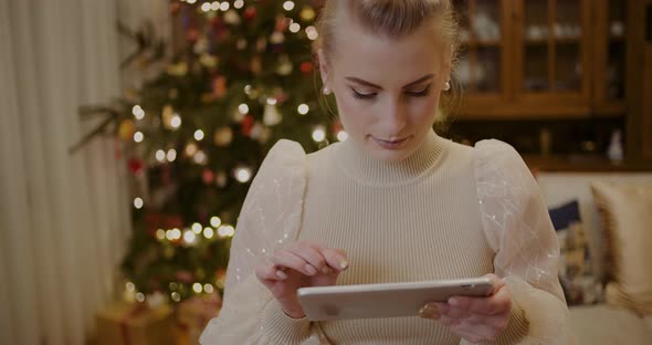 Woman Using Digital Tablet and Shopping Online During Christmas