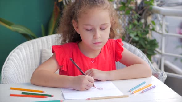 Cute Small Little Girl Artist Playing Alone Drawing Coloring Picture with at Home Relaxing Sits in