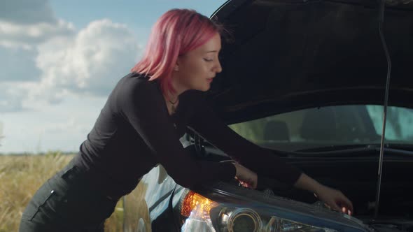 Confused Hipster Woman Inspecting Broken Car Engine