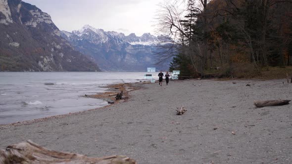 Sporty couple running along the shore of a mountain lake - digital generated tracking holograms for