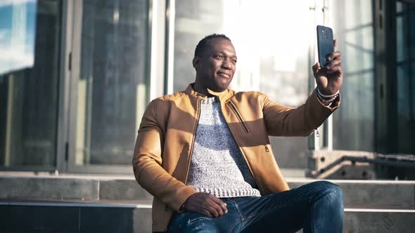 Young Cheerful African American Man Talking By Video Call on His Smartphone