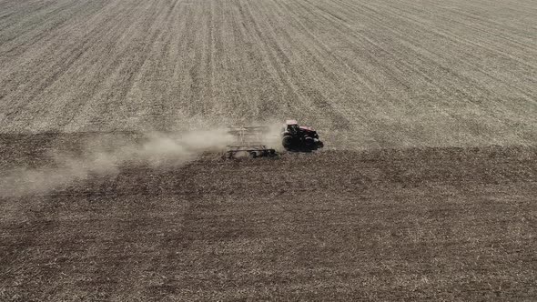 Farmer in Tractor Preparing Land with Seedbed Cultivator