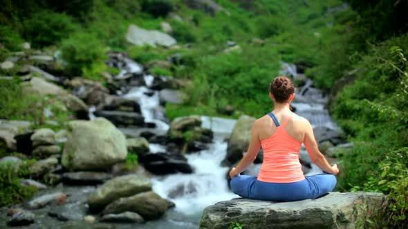 Woman Meditating at Tropical Waterfall