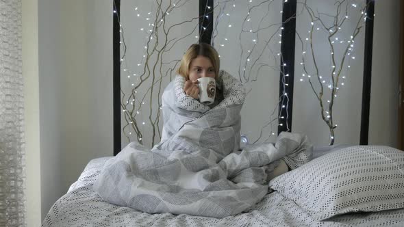 Girl drinking coffee in bed