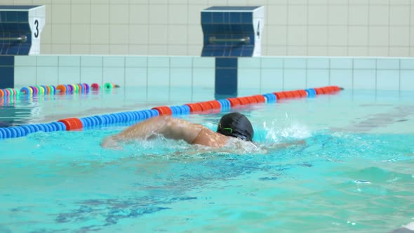 A Professional Swimmer Swims the Crawl in an Indoor Pool