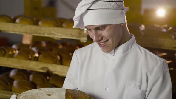 Happy Baker Rejoicing and Showing Large Round Loaf of Bread with Image of Smile