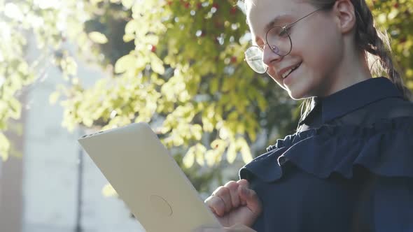 A Teenage Girl with a Tablet in the Park