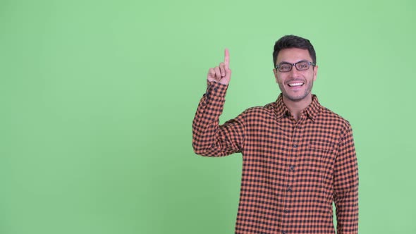 Happy Young Hispanic Hipster Man Pointing Up and Giving Thumbs Up