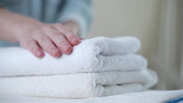 A Woman Touches a Fresh White Towel