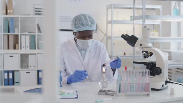 African Man Conducting Experiment Using Test-tube