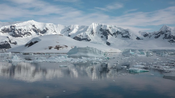 Icebergs are reflected in the water. Antarctic Nature. Majestic winter landscape.