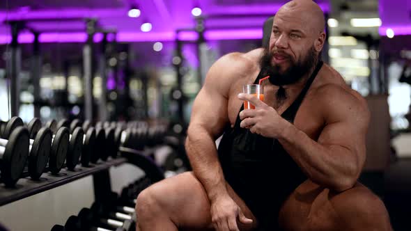 Jock is Resting After Training in Gym Drinking Vitamin Juice or Protein Cocktail for Healthy