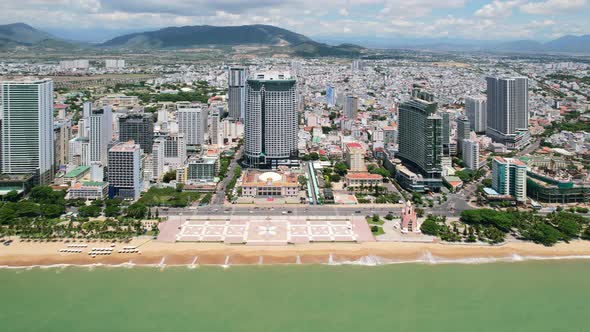 aerial drone parallel to the coastal city of Nha Trang Vietnam on a sunny day with turquoise ocean a