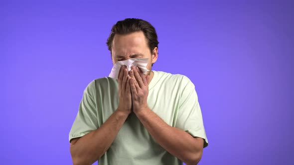 Handsome Man Sneezes Into Tissue