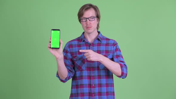 Young Handsome Hipster Man Pointing and Showing Phone