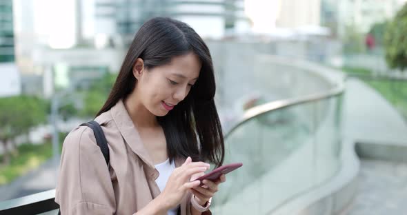 Asian woman sending sms on mobile phone