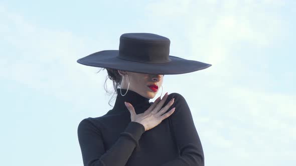 Beautiful Mysterious Woman in Black Hugging Herself Sensually