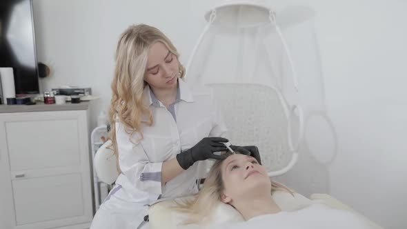 Young Pretty Blond Woman Receiving Treatments in the Beautician Office Lying on the Couch