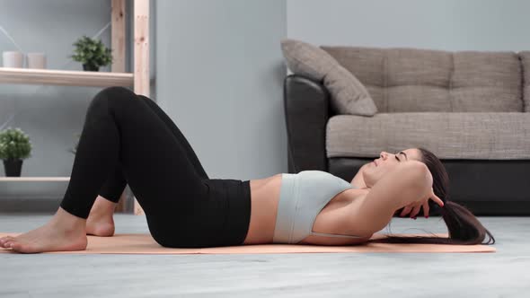 Fitness Woman in Sportswear Doing Abs Exercise Lying on Floor