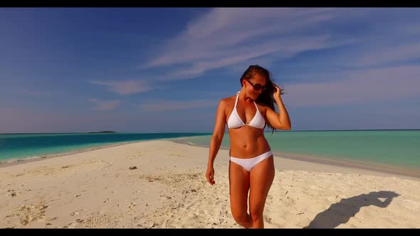 Single lady sunbathes on tranquil coast beach holiday by shallow lagoon and white sandy background o