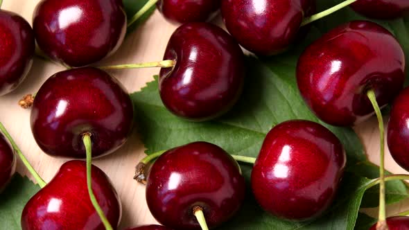 Ripe sweet cherry rotating top view on wooden background