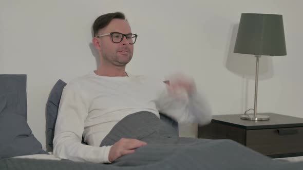 Upset Casual Man Feeling Worried While Sitting in Bed