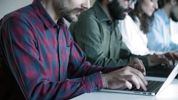 Side View of Concentrated Developers Working with Laptops