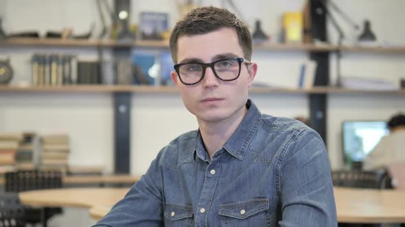 Portrait of Creative Young Man in Glasses Looking at Camera