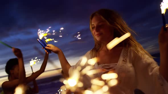 Friends playing with sparklers on the beach 4k