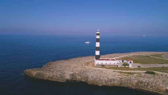 Lighthouse on rocky cliff near sea