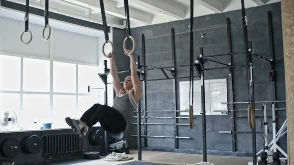 Muscular Woman Exercising on Rings