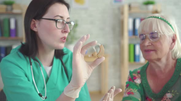 Doctor Audiologist Tells an Elderly Woman About the Hearing Aid