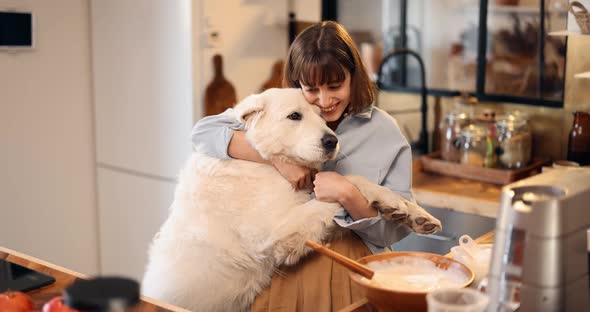 Woman Playing with Her Huge Dog While Cooking at Home