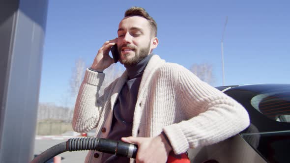 Driver Speaking on Phone while Refueling Car