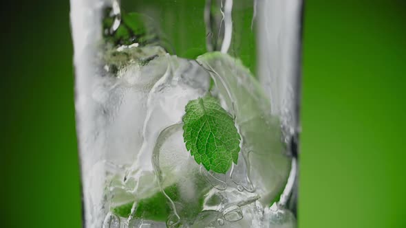 Alcohol is Being Poured in Slow Motion to the Highball Glass with Mojito Ingredients Making the