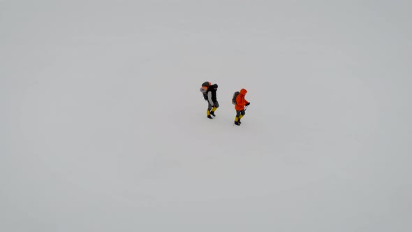 Aerial View of Two Male Hikers Walking in Untouched Snow Landscape. Aventures Journey Trip Scenery