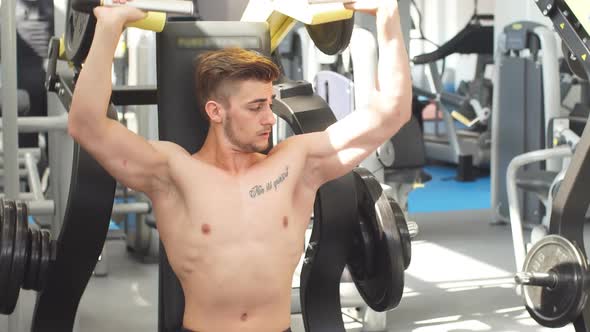 Young Athlete Trains in the Gym. Bodybuilder Pumping Up Upper Body Muscules.
