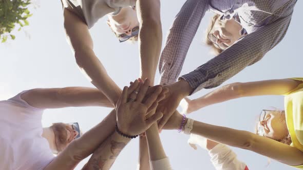 Group of Young People Putting Hands Together in Circle