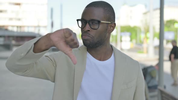 Thumbs Down By African Man Standing Outdoor