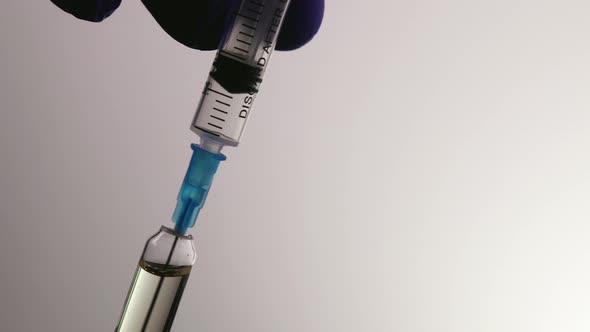 Doctor Dials the Vaccine Into the Syringe for Injection