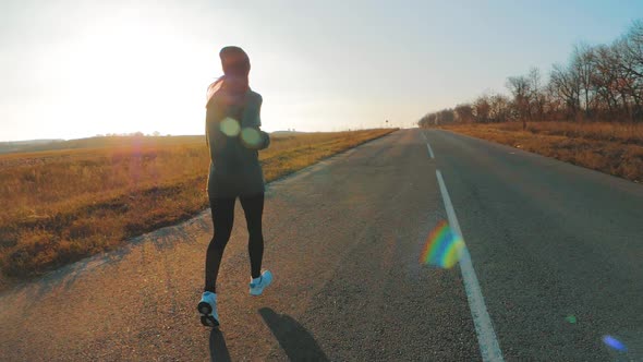 Young Fitness Sport Woman Running on Road at Sunset. Athlete Runner Feet Running on Road, Slow