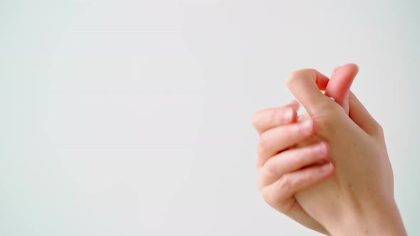 Female Applying Hand Cream Against White Background Close Up