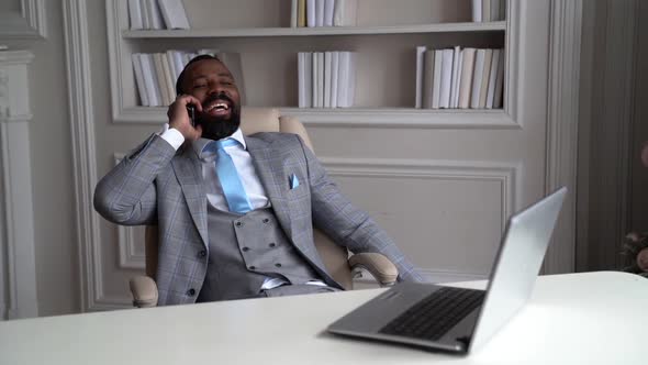 Happy Successful Businessman Is Sitting at Working Office and Calling By Mobile Phone