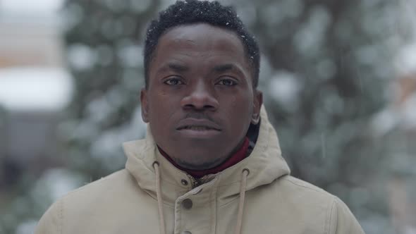 Closeup Portrait of Joyful African American Man Smiling Looking at Camera in Snowfall