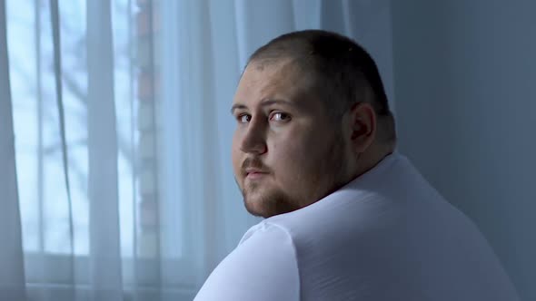 Sad Obese Man Looking at Camera Hopelessly, Depression Caused Health Problem