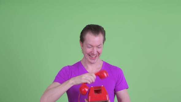 Face of Happy Young Handsome Man Using Old Telephone