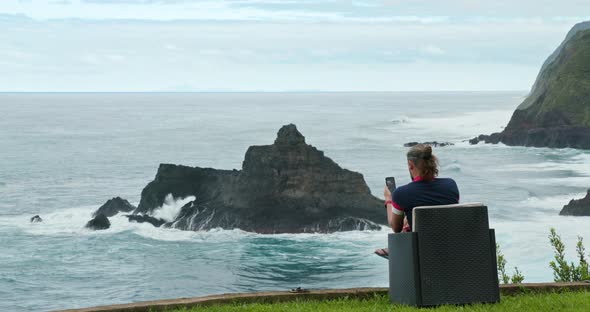 Caucasian Male Traveler Texting in the Picturesque Area of the Peninsula