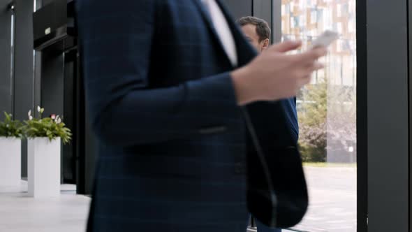 Two Businessmen Talking in Office Hall