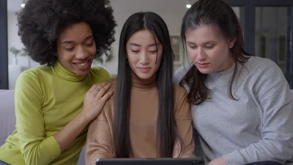 Middle Shot of Female Multinational Friends Surfing Internet Talking and Smiling