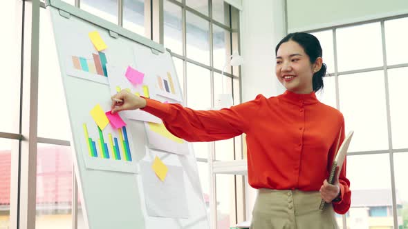 Young Woman Explains Business Data on White Board